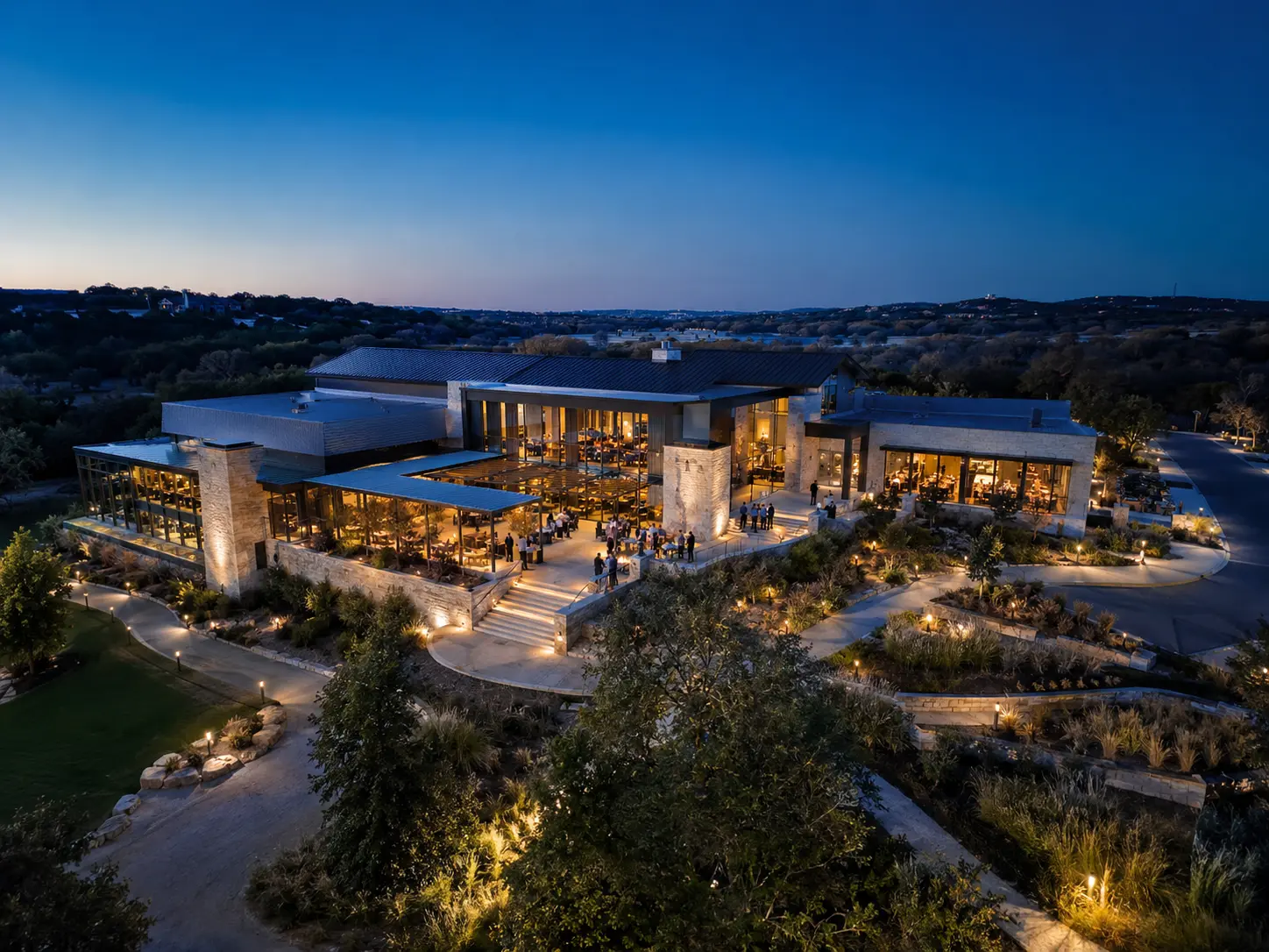 Blue-hour aerial view of a contemporary commercial venue