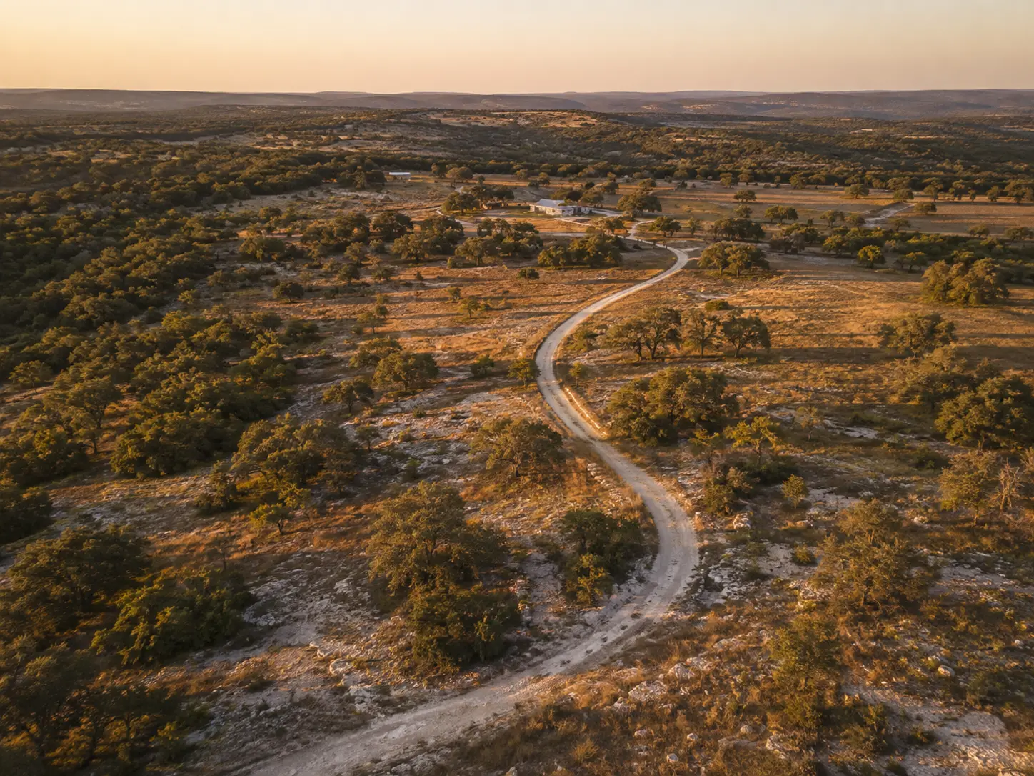Aerial view across a Texas Hill Country ranch at golden hour
